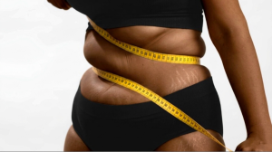 black woman measuring weight with tape